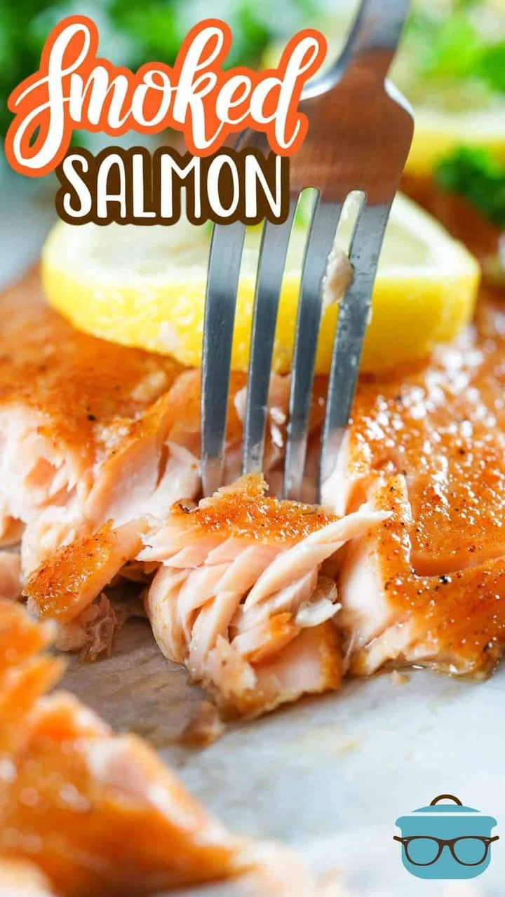 Perfectly cooked smoked salmon on a wooden board with herbs