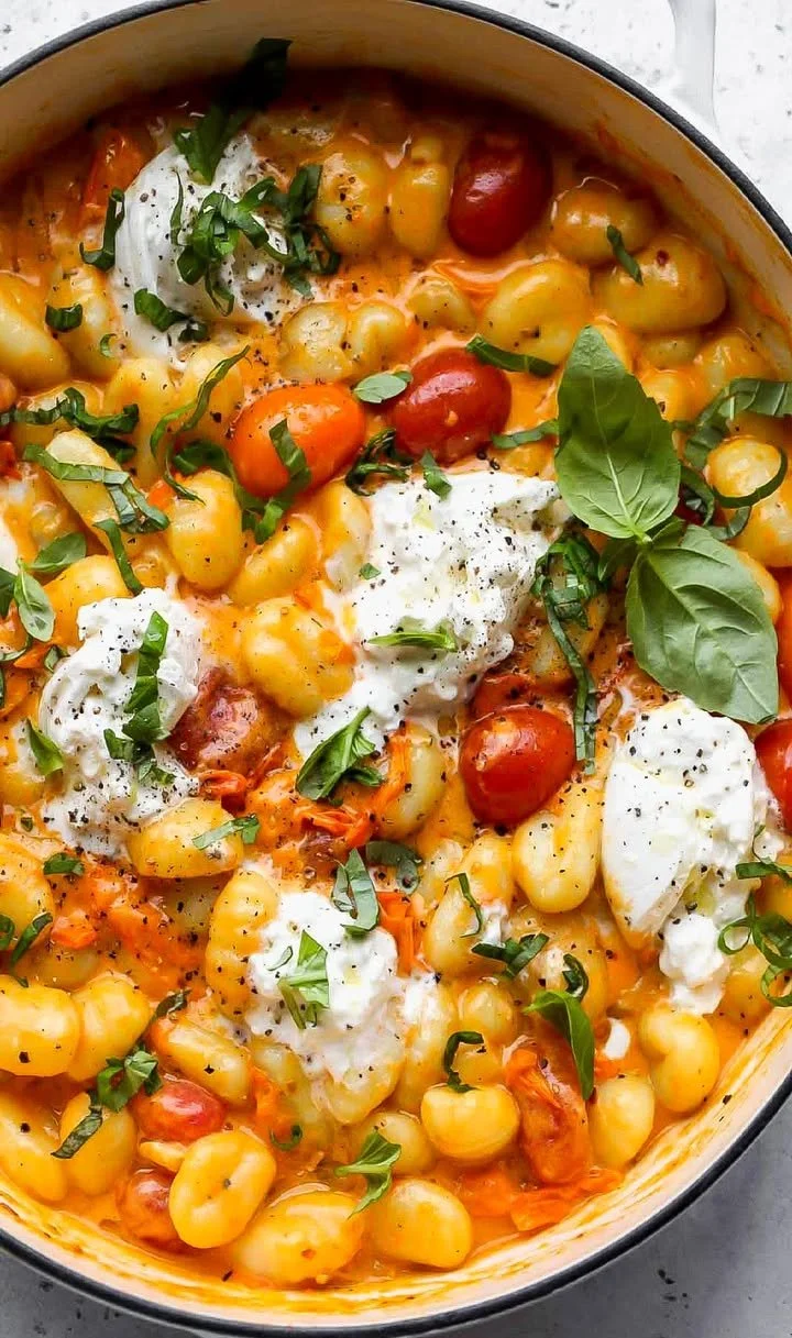 Creamy tomato gnocchi topped with burrata cheese in a bowl
