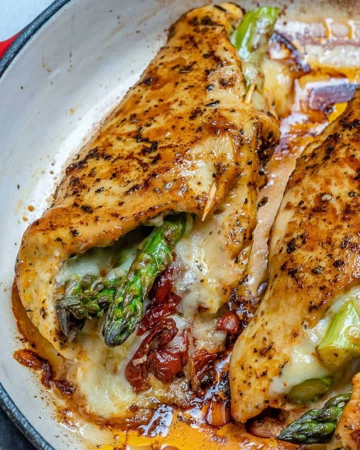 Asparagus stuffed chicken breast dish garnished with herbs