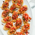 Plate of authentic Italian bruschetta topped with tomatoes and basil