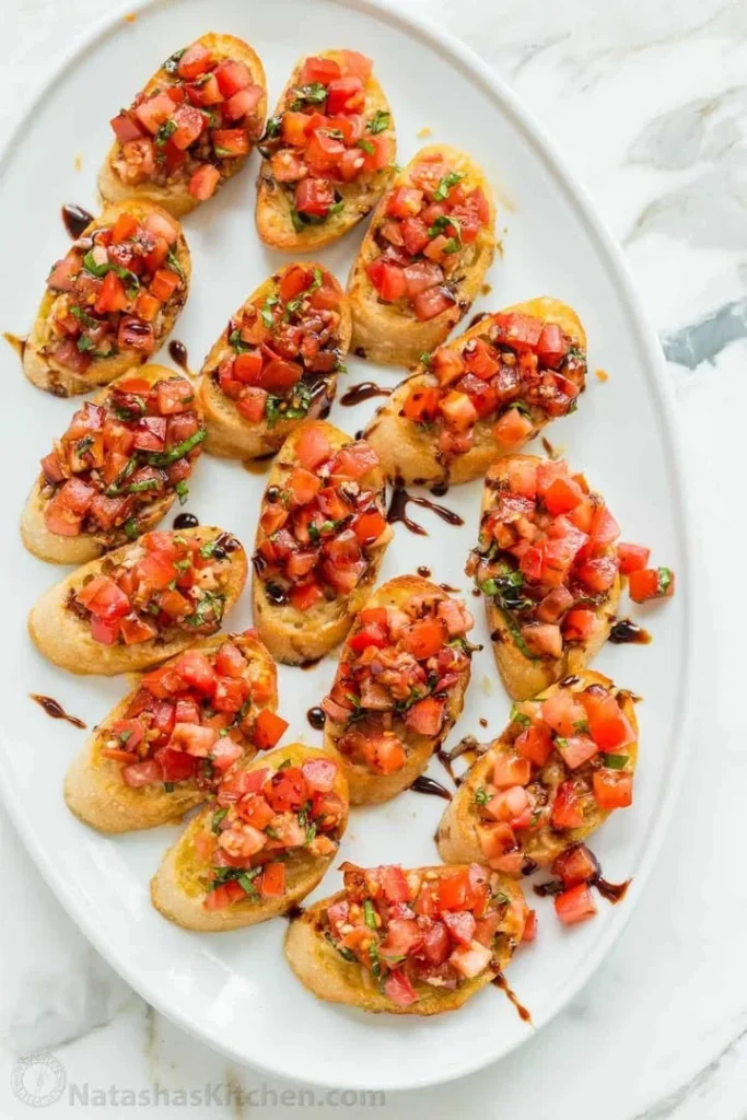 Plate of authentic Italian bruschetta topped with tomatoes and basil