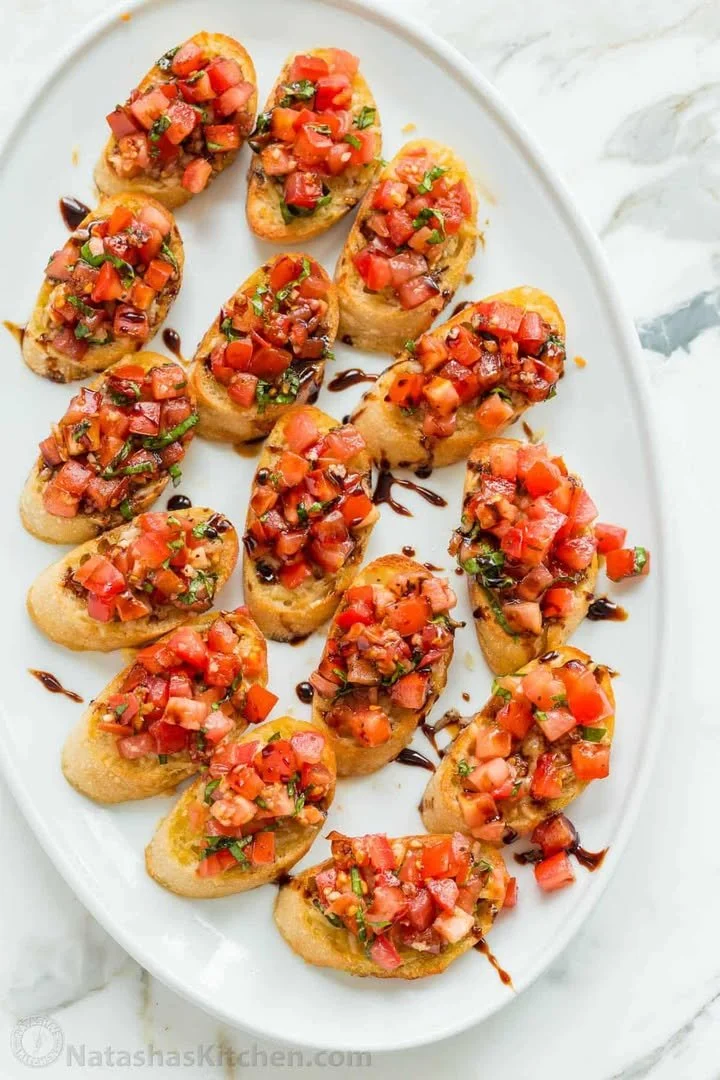 Plate of authentic Italian bruschetta topped with tomatoes and basil
