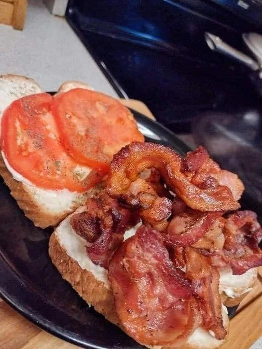 Delicious bacon and tomato sandwiches on a plate with fresh ingredients