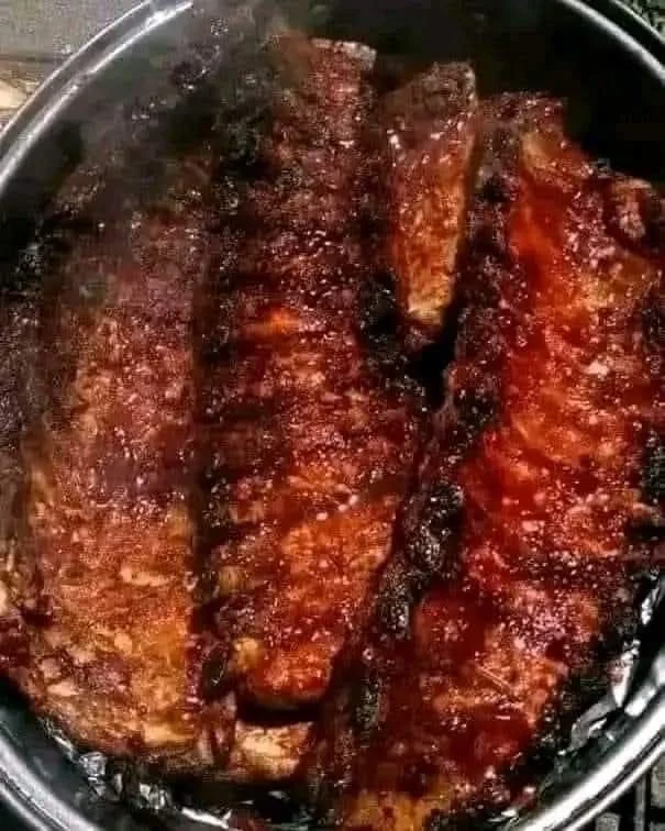 Delicious Baked BBQ Baby Back Ribs served on a plate with a side of coleslaw.