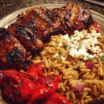 Balsamic glazed chicken with gluten-free orzo, feta, and roasted red peppers served on a plate.