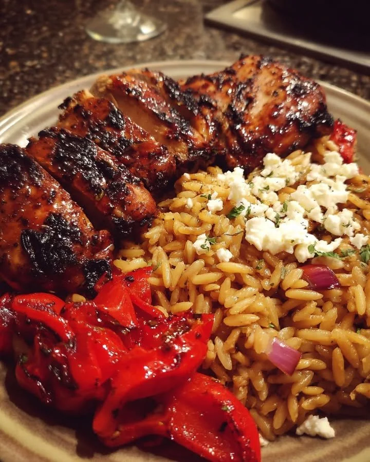 Balsamic glazed chicken with gluten-free orzo, feta, and roasted red peppers served on a plate.