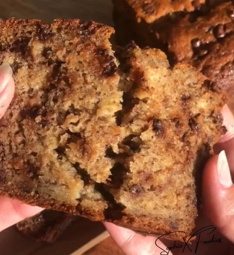 Loaf of moist homemade banana bread sliced on a wooden board