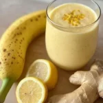 Banana Lemon Ginger Smoothie in a glass garnished with lemon slice and ginger