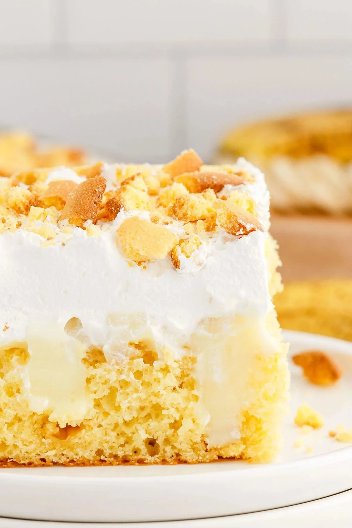 Delicious Banana Pudding Poke Cake topped with whipped cream and banana slices.