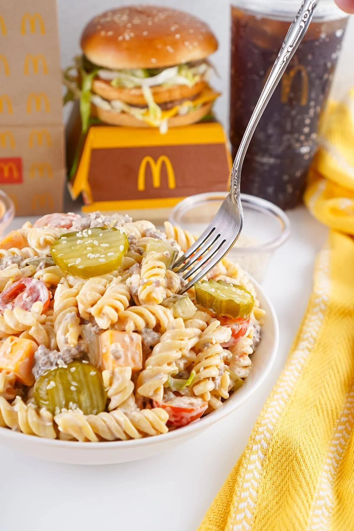 A bowl of Big Mac Pasta Salad with fresh ingredients and dressing.