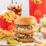 Big Mac Sloppy Joes on a plate with toppings and ingredients nearby