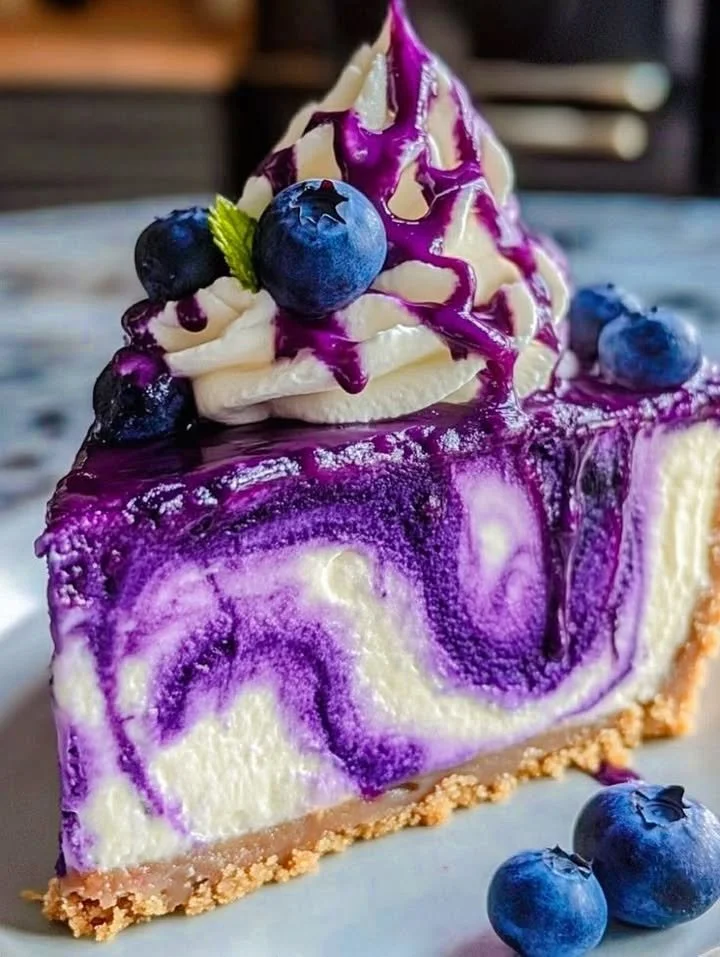 A slice of blueberry swirl cheesecake topped with fresh blueberries.