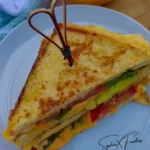 Delicious breakfast sandwich with eggs, cheese, and bacon on toasted bread.