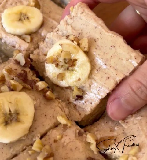 Delicious Brown Butter Frosted Banana Bread Bars served on a wooden plate.