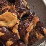 Delicious brownies and blondies on a plate with chocolate drizzle