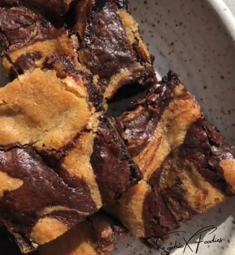 Delicious brownies and blondies on a plate with chocolate drizzle