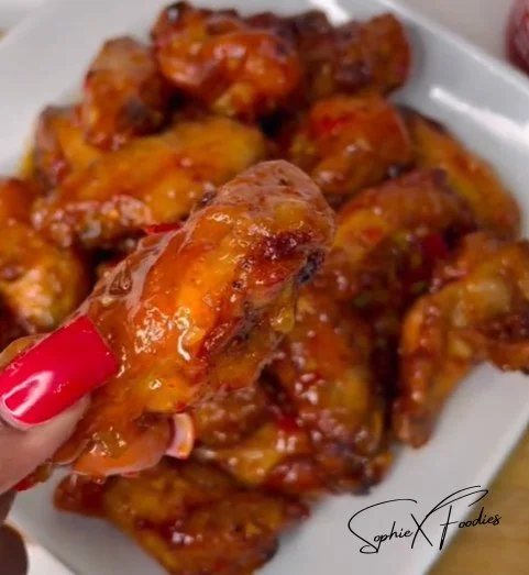 A plate of spicy Buffalo Chicken Wings garnished with celery and blue cheese dipping sauce.