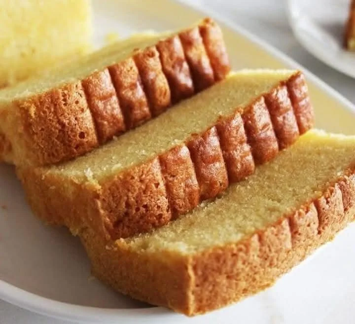 Delicious butter cake sliced on a plate, showcasing its rich texture.