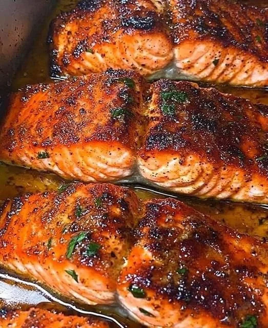 Cajun Honey Butter Salmon served with fresh herbs and side vegetables