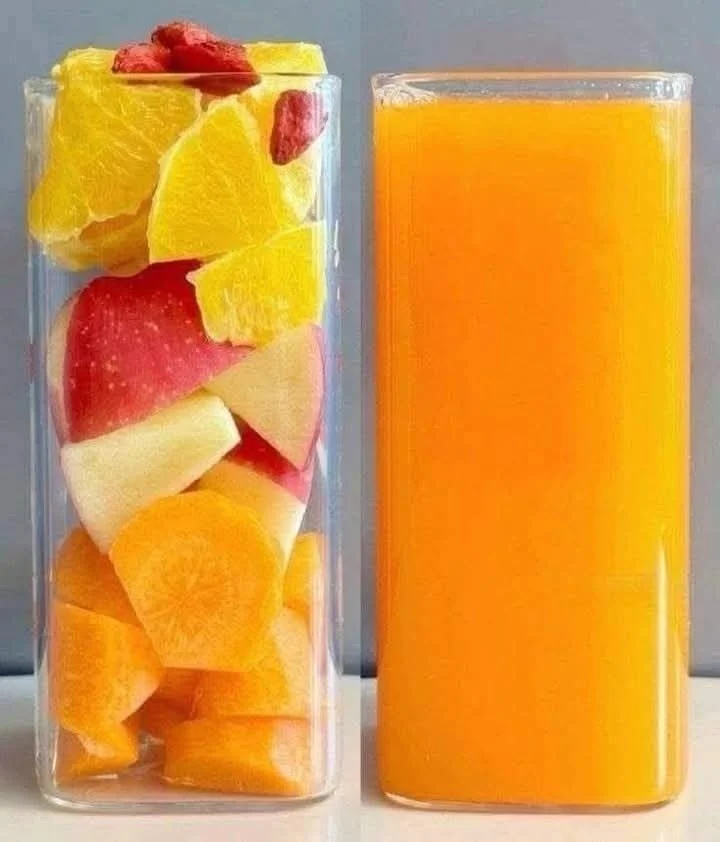 Carrot orange apple smoothie in a glass garnished with fruits and carrots