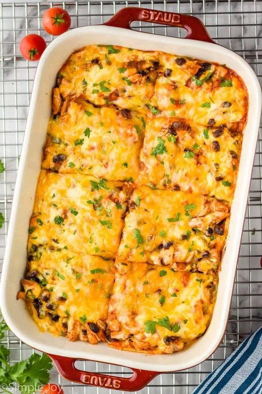 Delicious Chicken Enchilada Casserole topped with cheese and salsa.