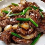Chinese beef and onion stir fry in a colorful vegetable mix.