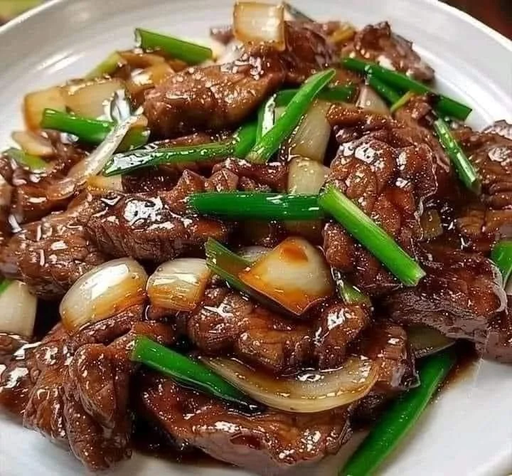 Chinese beef and onion stir fry in a colorful vegetable mix.