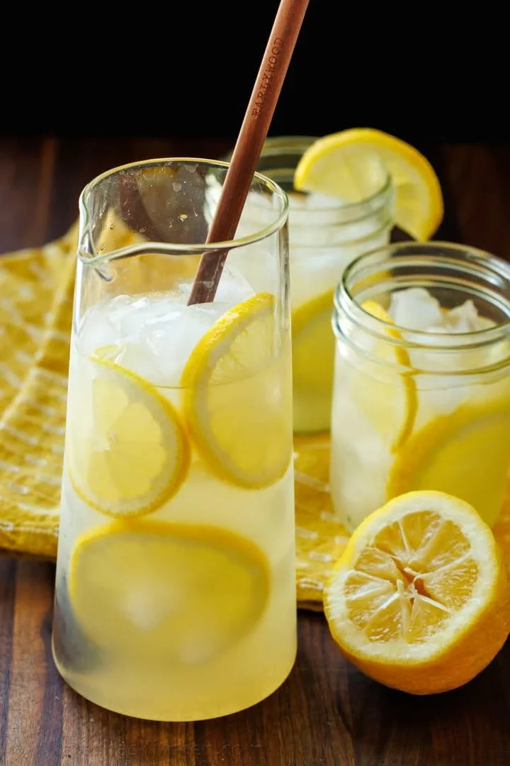 Classic lemonade in a glass with lemon slices and mint leaves