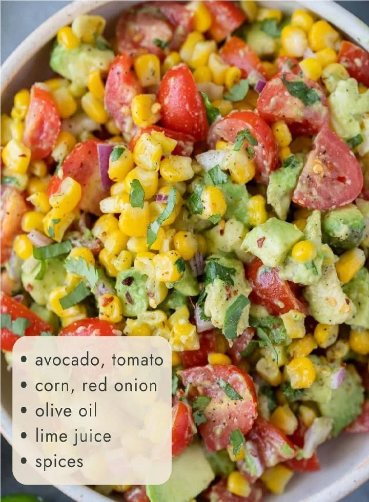 Colorful Corn Tomato Avocado Salad in a bowl garnished with herbs