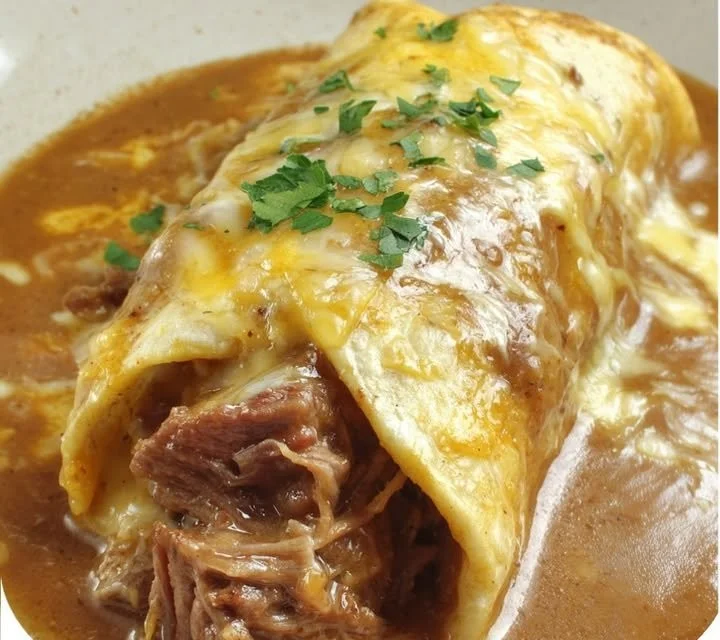 Delicious creamy Chile Colorado burritos topped with savory sauce and fresh ingredients.