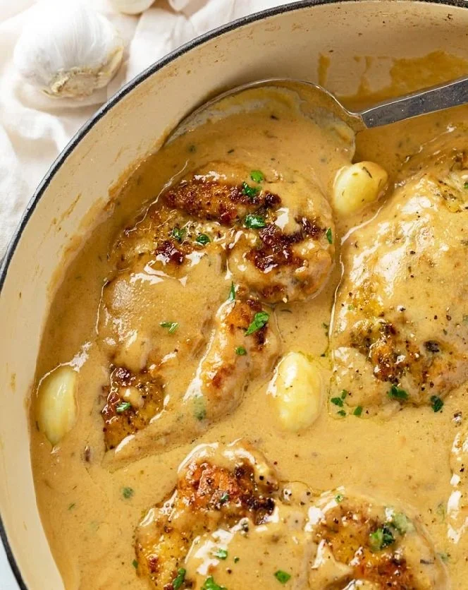 Creamy garlic chicken dish garnished with herbs on a plate