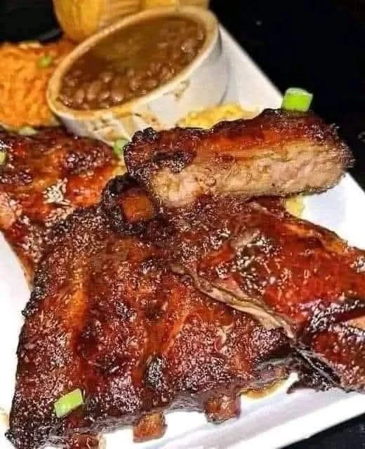Crockpot barbecue ribs served with a side of coleslaw and corn bread
