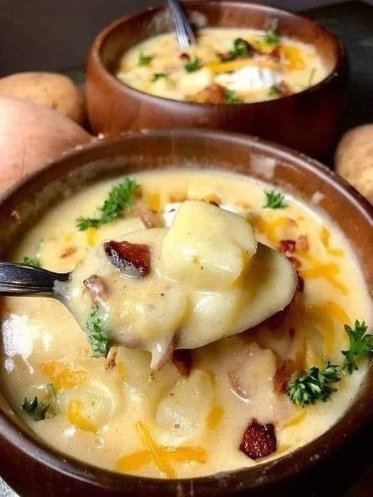 Bowl of creamy potato soup garnished with herbs and spices