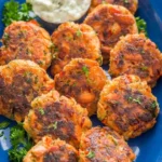 Delicious homemade salmon patties served on a plate with fresh herbs.