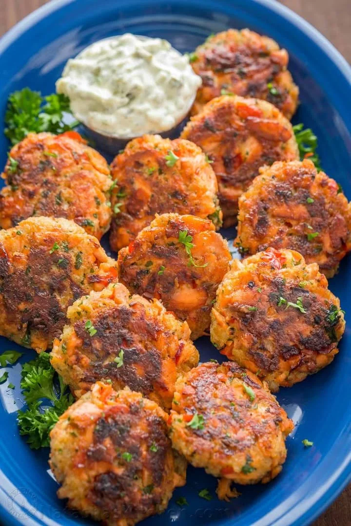 Delicious homemade salmon patties served on a plate with fresh herbs.