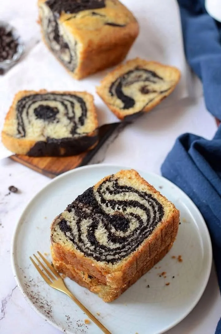Eggless marble cake topped with chocolate and vanilla swirls