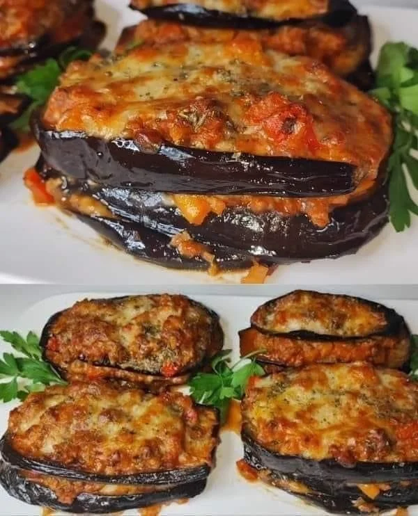 Plate of baked eggplant with minced meat filling, garnished with herbs.