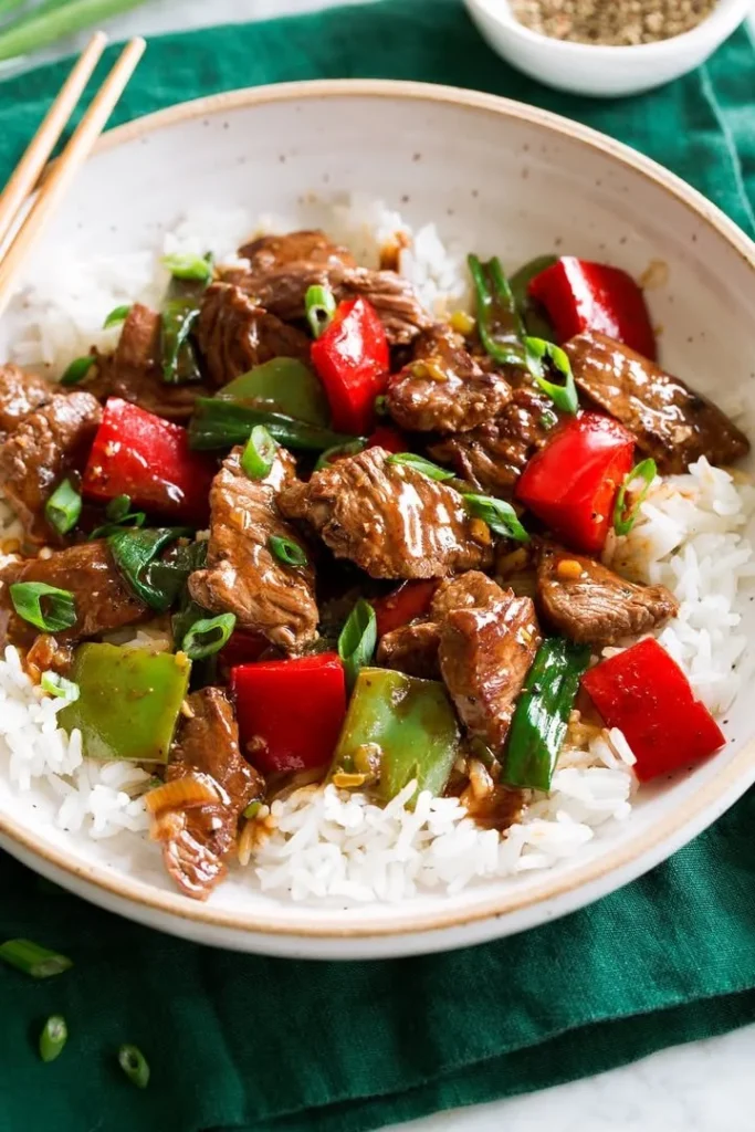 A savory flank steak stir-fry served with colorful vegetables in a bowl.