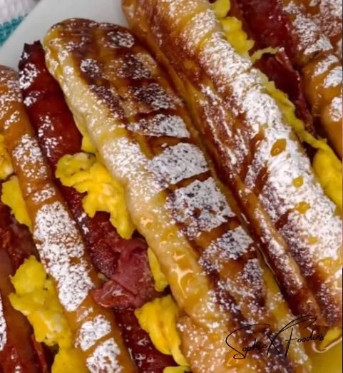 French toast breakfast hotdogs topped with syrup and berries