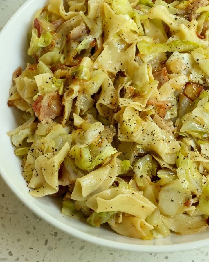 Delicious fried cabbage with bacon, onion, and garlic served in a skillet