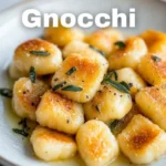 Plate of homemade gnocchi served with tomato sauce and fresh basil.