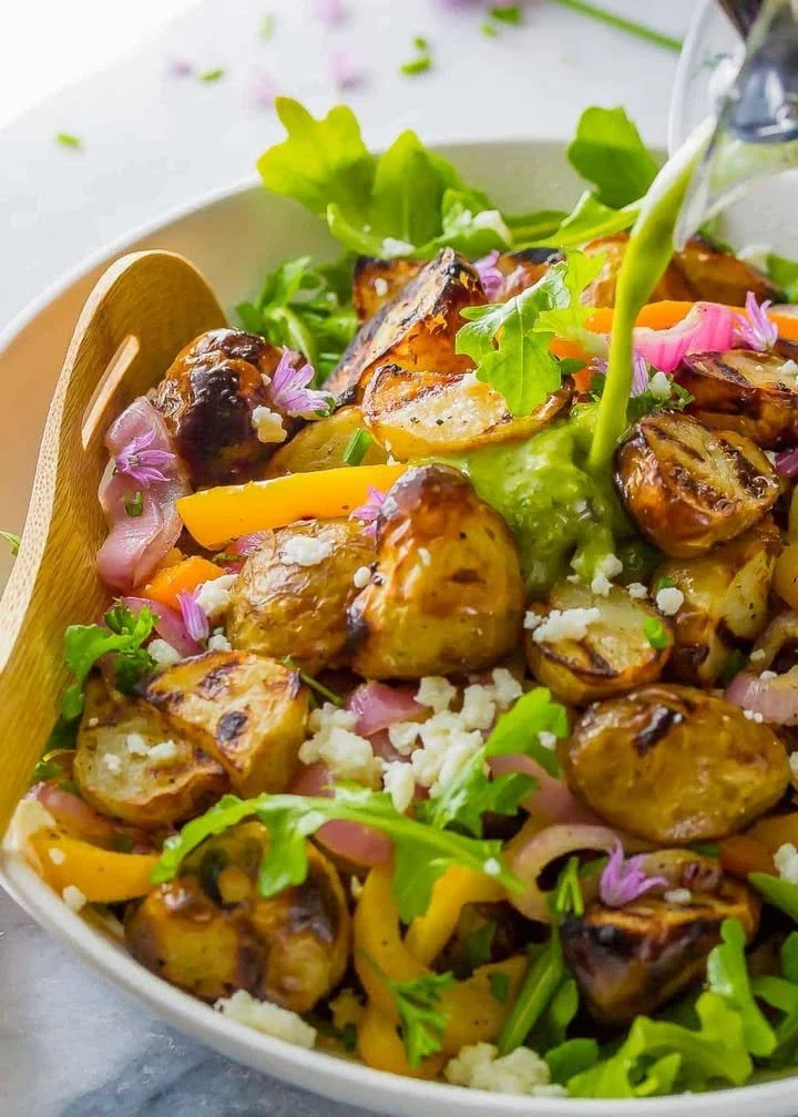 Delicious grilled potato salad garnished with fresh herbs and vegetables