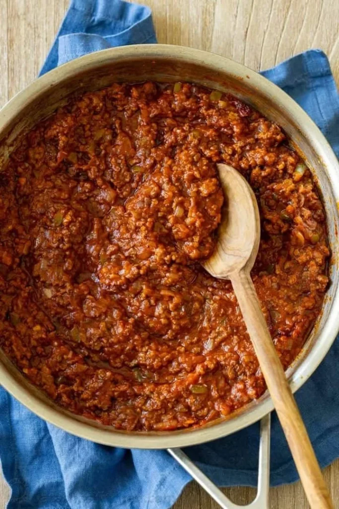 Homemade sloppy joe sandwich on a plate with fresh ingredients