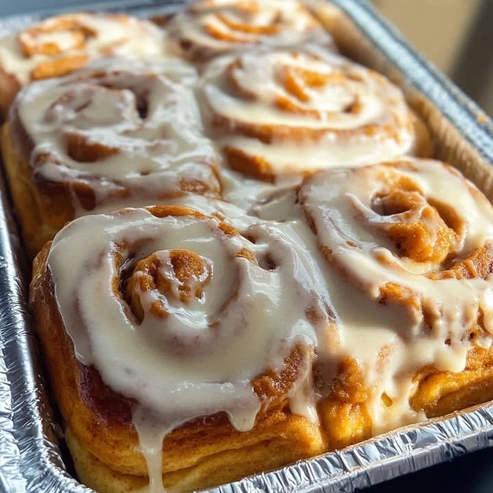 Homemade sweet potato pie cinnamon rolls topped with cinnamon sugar and cream