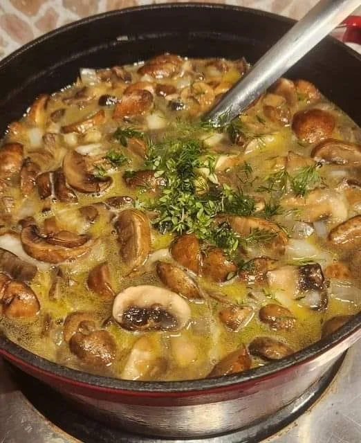 Bowl of rich and creamy Hungarian Mushroom Soup garnished with herbs