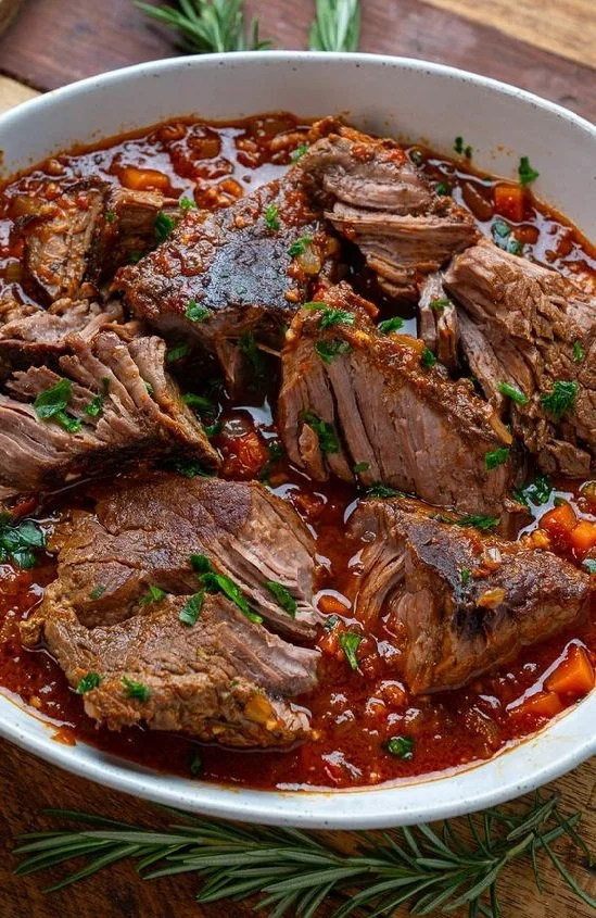 Delicious Italian pot roast garnished with fresh herbs and served with vegetables
