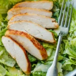 Juicy baked chicken breast served with herbs and spices on a plate