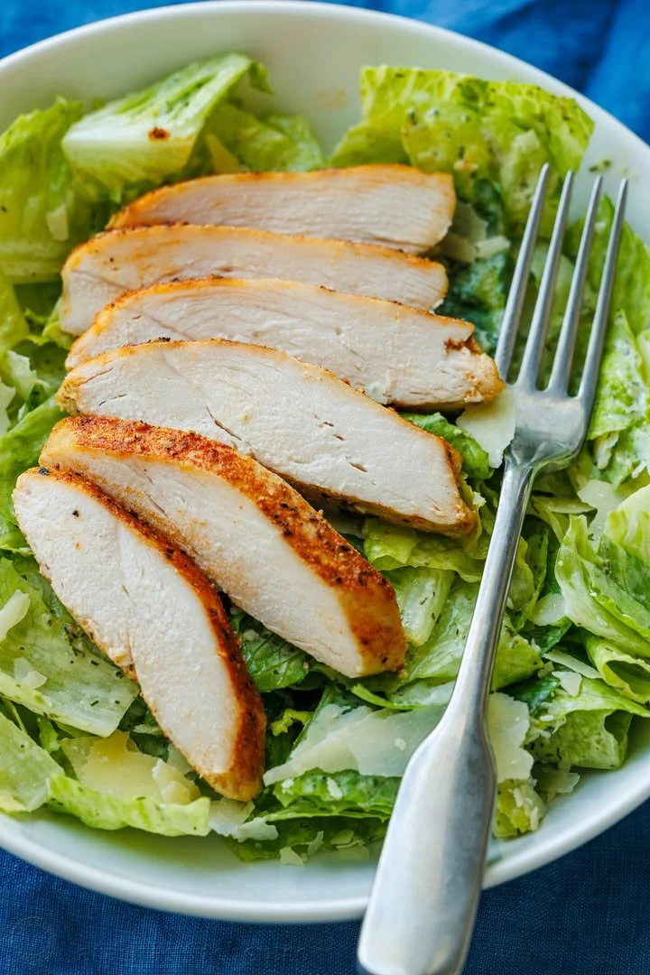 Juicy baked chicken breast served with herbs and spices on a plate