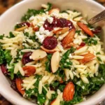 A vibrant Kale and Orzo Salad with cranberries and almonds presented in a bowl.