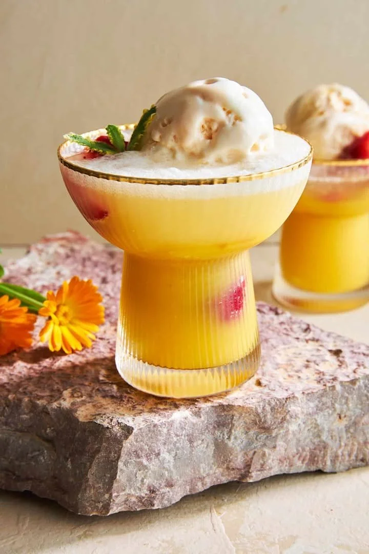 Mango and vanilla ice cream float in a glass with colorful straws
